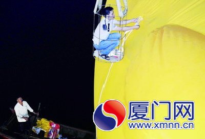 工人給大黃鴨系上繩子，準備起吊