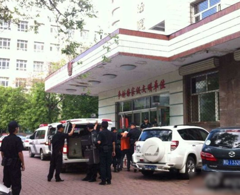 兩名犯罪嫌疑人頭戴面罩，被法警押進法庭。2