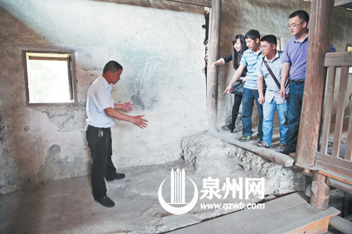 許進(jìn)丁向游客們比劃著土樓墻體的厚度，當(dāng)年建造土樓